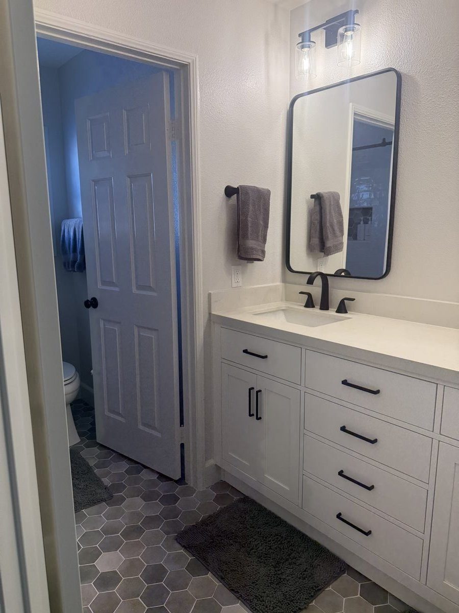White vanity with hexagon tile floor