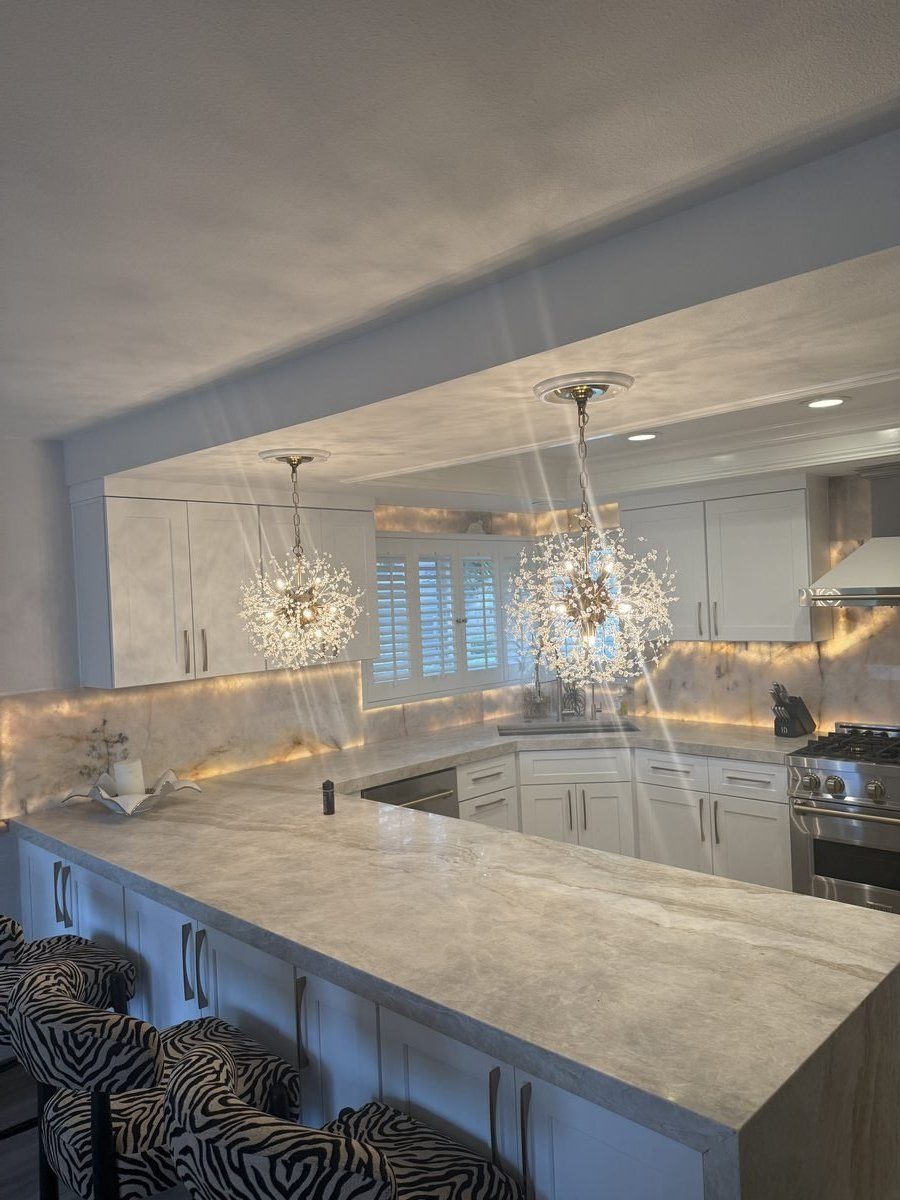 Kitchen peninsula with backlit stone backsplash