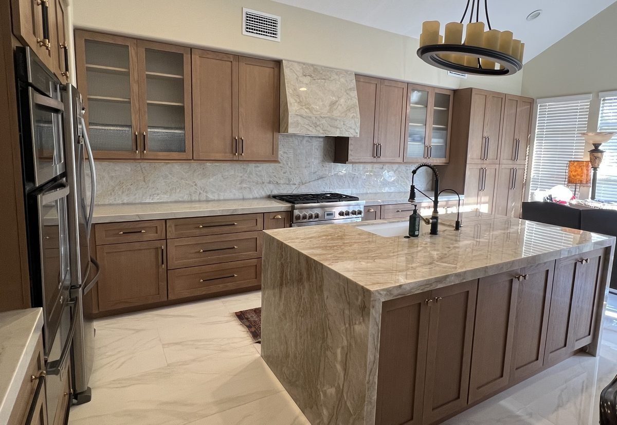 Custom stone range hood and waterfall island